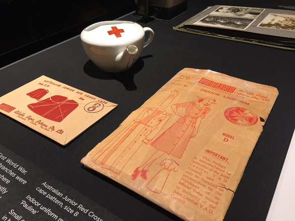 Australian Junior Red Cross cape pattern, size 8; Indoor uniform model D pattern, 'Pauline'; Small cup used to feed patients in hospitals, c. 1916