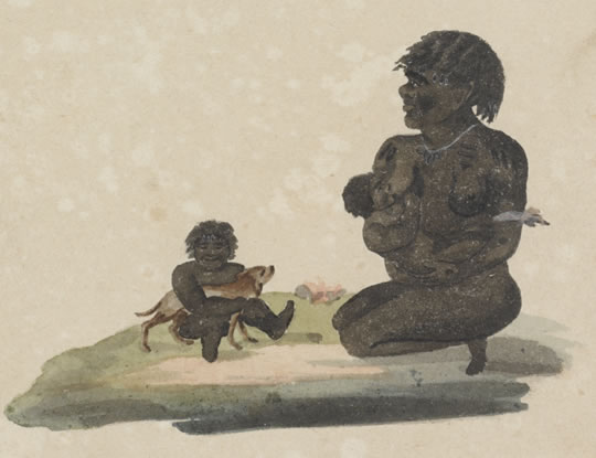 An Aboriginal woman holding a baby kneels beside a small child who is holding a dog.