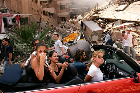Young Lebanese drive through devastated neighborhood of South Beirut, 15 August